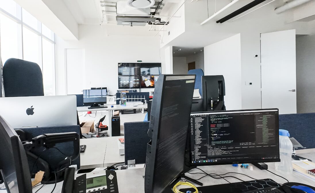 Oficinas EDIS · open space industrial blanco con desarrollo en pantallas